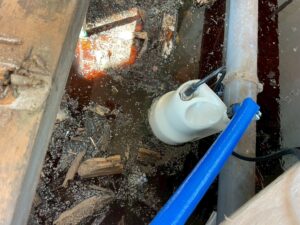 床下に溜まった水の排水作業